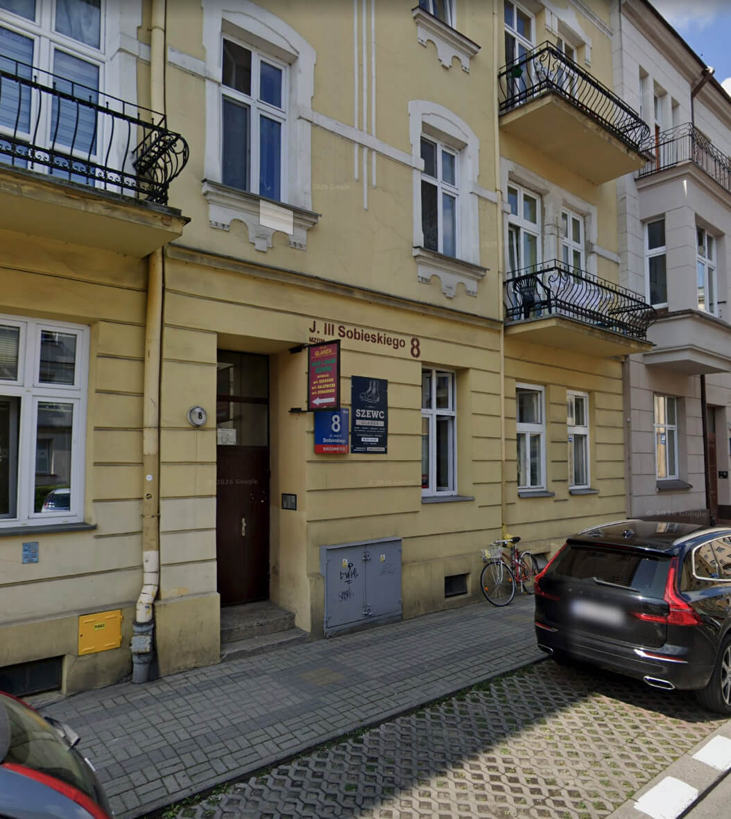 Kamienica przy ul. Jana III Sobieskiego 8 w Rzeszowie — brama zakładu szewskiego Glanek i szyld „Szewc” od strony ulicy